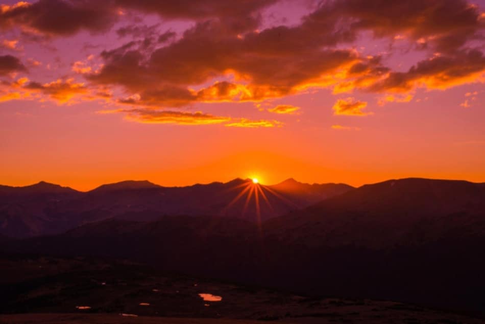 Sun setting behind mountains