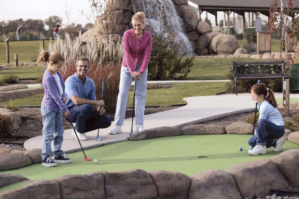 Family playing mini golf