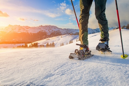 man walking with technical snowshoes