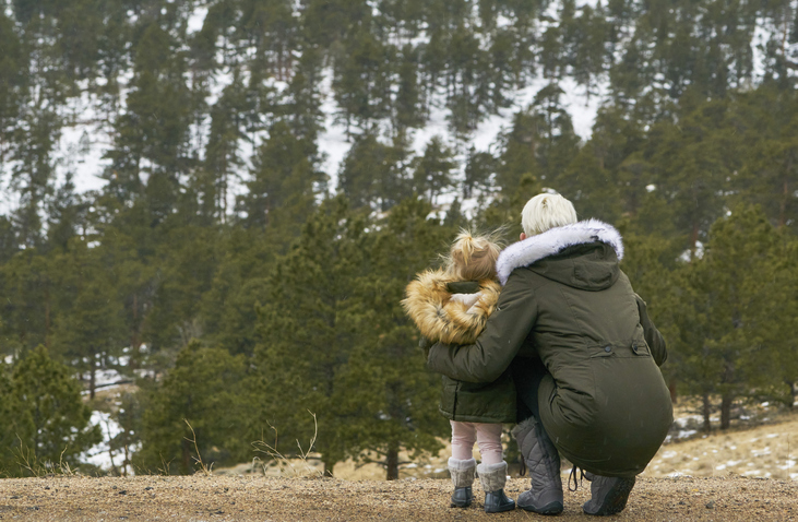 Mother and daughter looking at Elk in the winter scenery in Rocky Mountain National Park outside of Estes Park, Colorado.