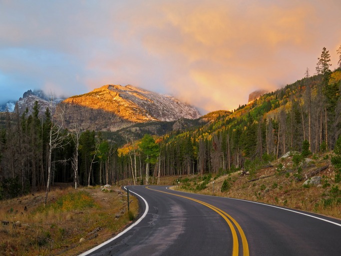 The peaks light up at sunrise along Bear Lake Road in Rocky Mountain National Park.