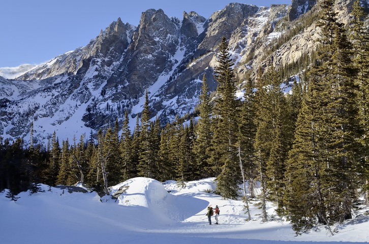 People hiking in the beautiful Rocky Mountains in winter. Taken at Dream Lake in Rocky Mountain National Park, Colorado.